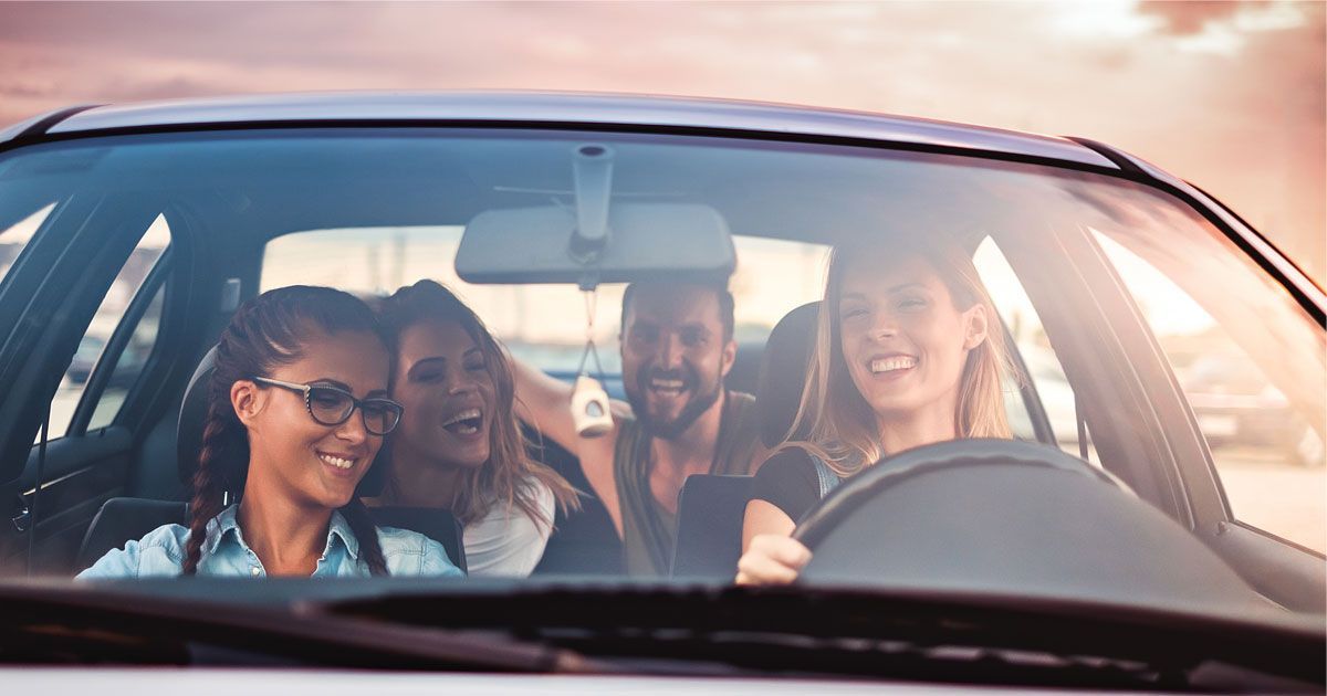 BlaBlaCar Uruguay: cuatro pasajeros disfrutan un viaje compartido en auto al atardecer, ilustrando el carpooling que llega al país el 26 de mayo de 2026